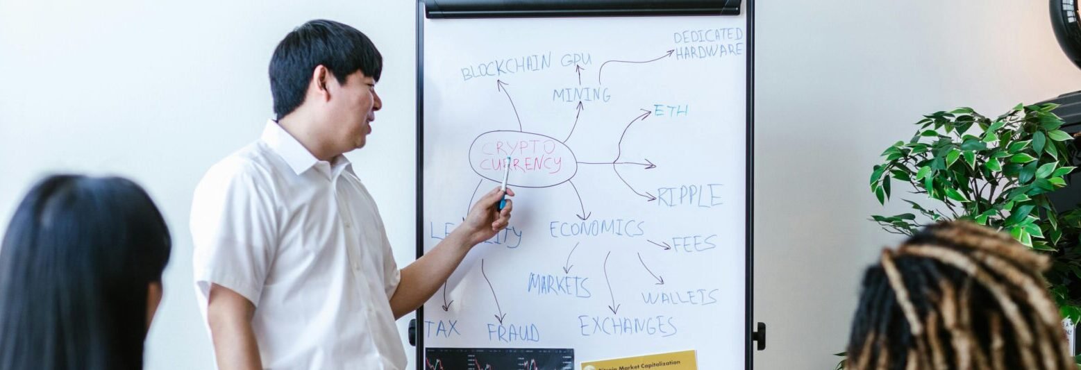 Trainer giving a presentation on blockchain concepts to a diverse group in a modern office.